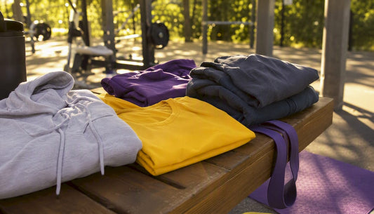 Folded gym hoodies and t-shirts on bench