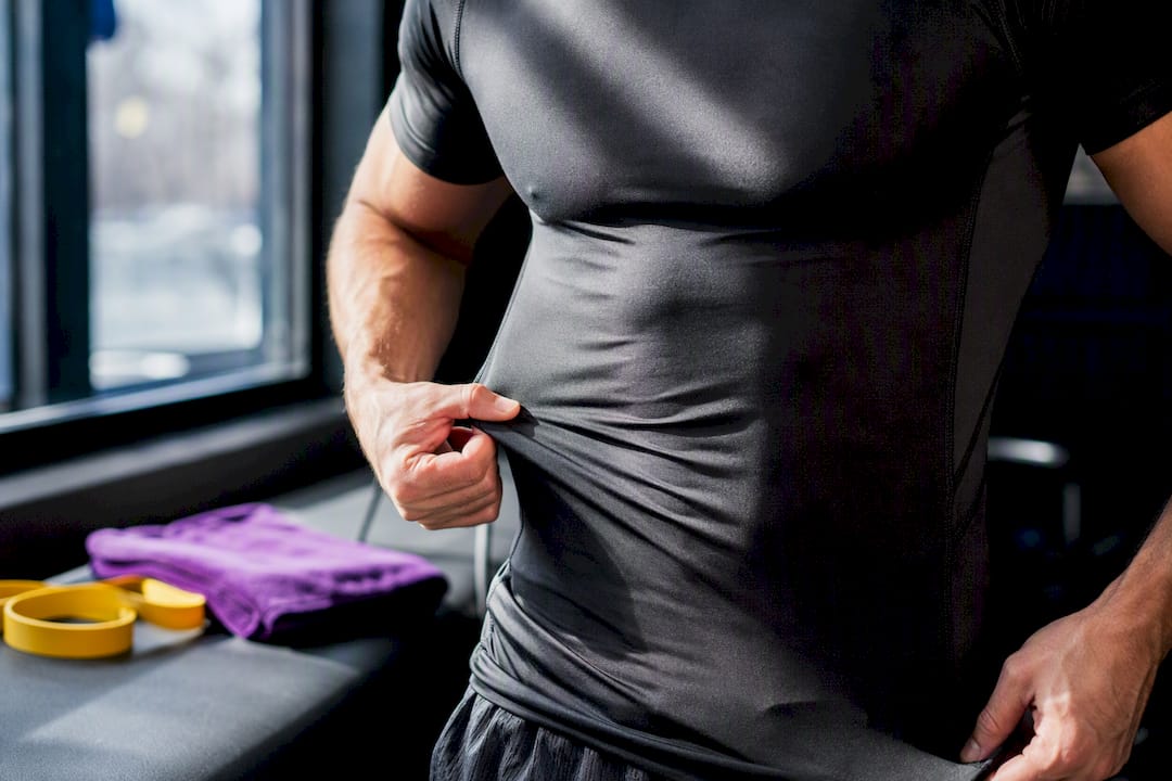 Athlete checking compression shirt fit after training