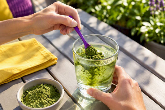 Green powder stirred into a clear drink