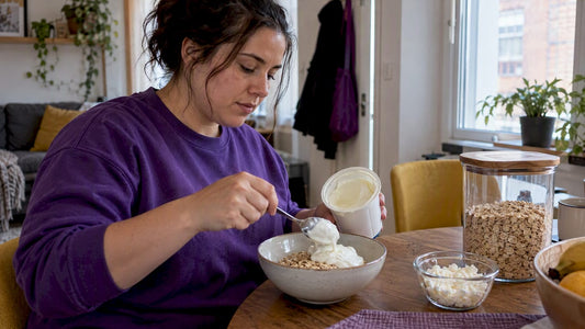 Woman preparing a Greek yogurt and oats breakfast