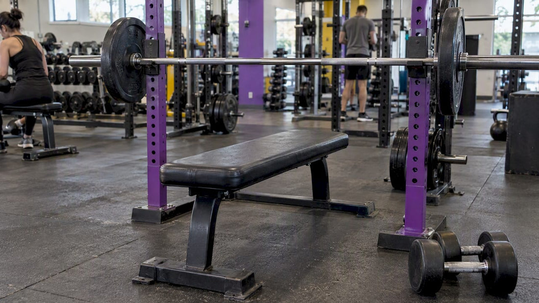 Barbell and dumbbells beside a weight bench
