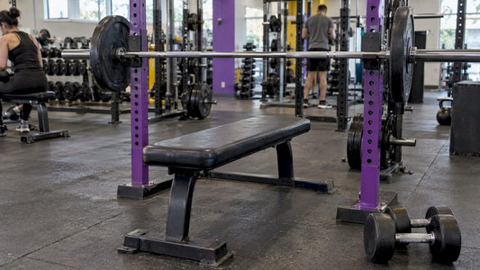 Barbell and dumbbells beside a weight bench